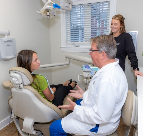 Dentist, patient, and hygienist all giving a thumbs up
