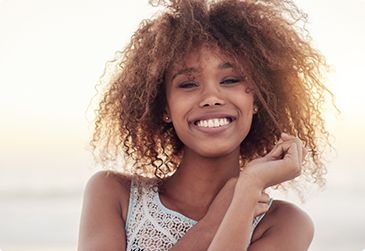 Woman in white shirt smiling on beach