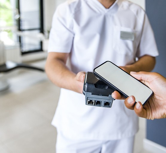 Hand holding out smartphone to pay for service 