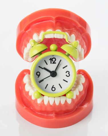 Fake teeth biting a timer